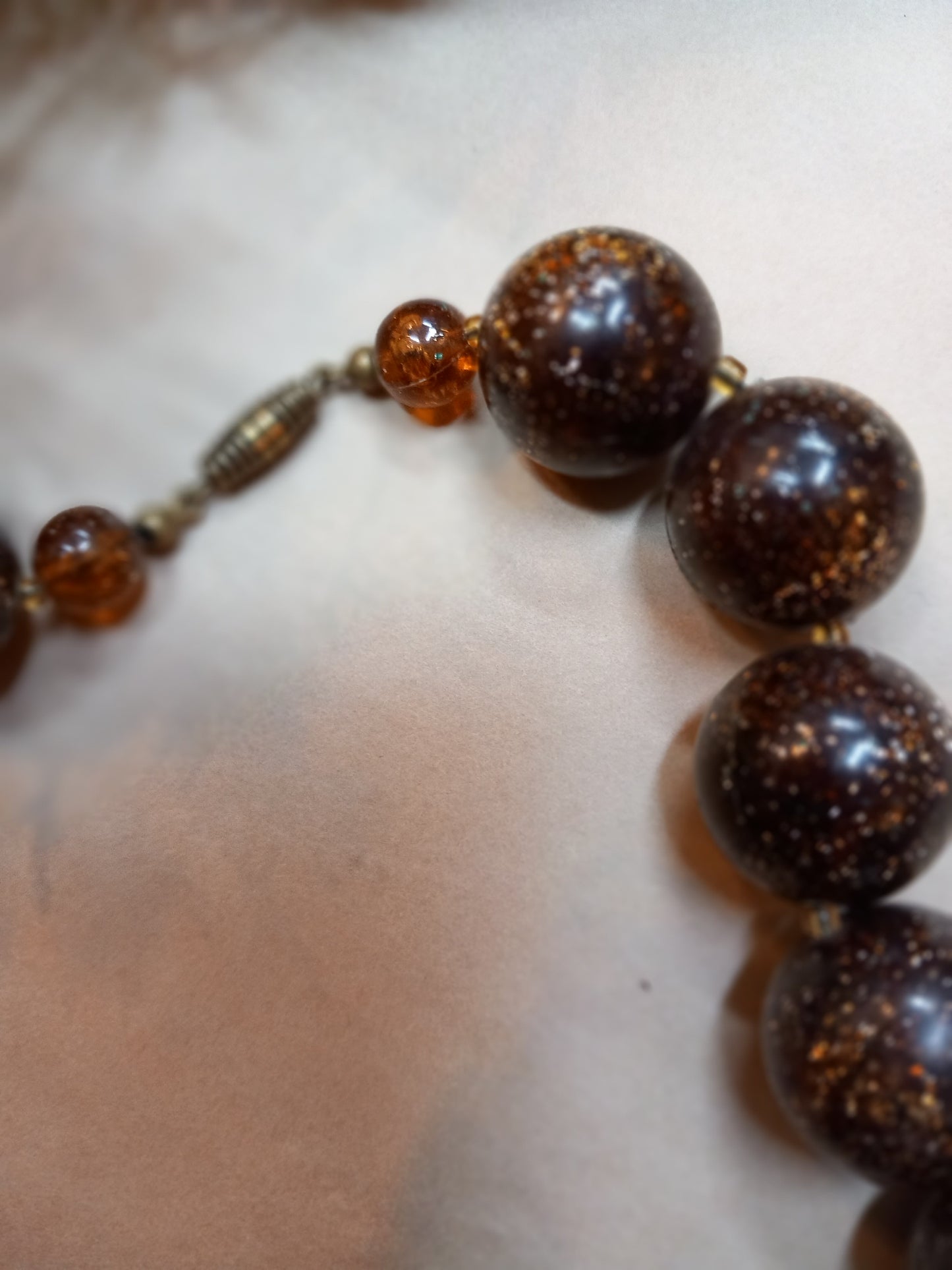 Halskæde, brune perler med glimmer.