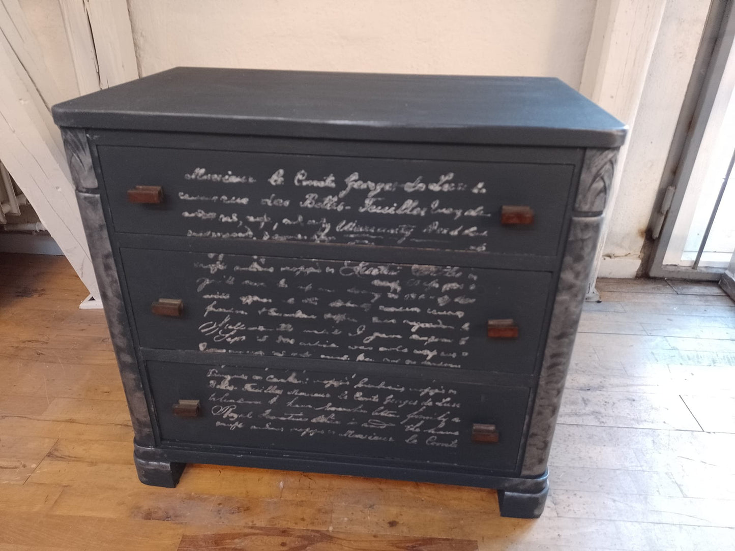 Kommode med sølv tekst på fronten